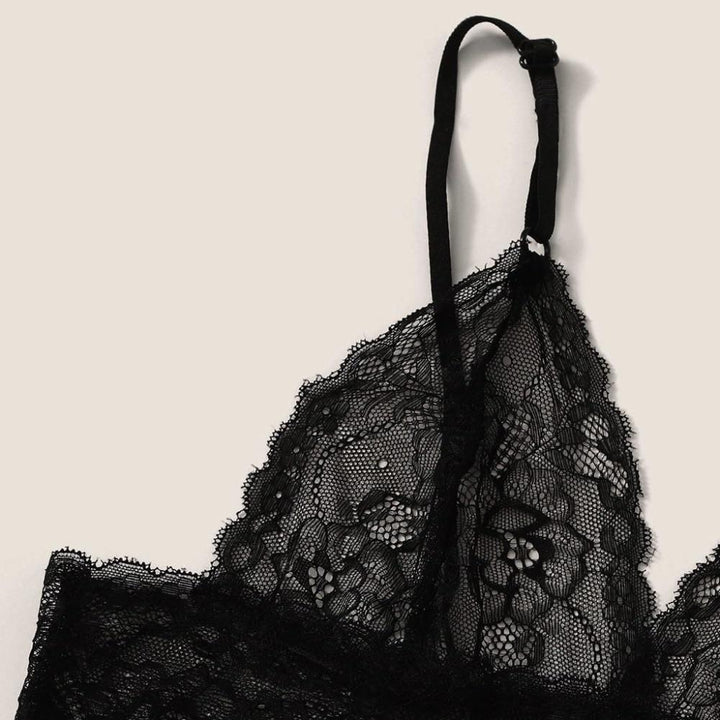 Black lace bralette with adjustable straps and floral lace detailing.