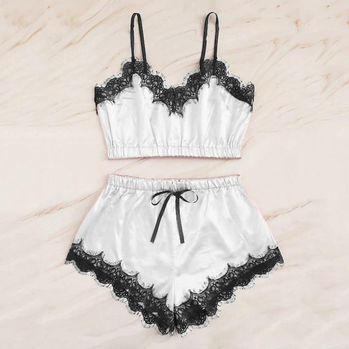 Silky white lingerie set featuring a lace-trimmed bralette and matching shorts with a bow tie.