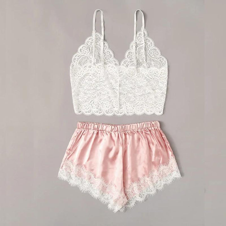 Lace bralette with adjustable straps and silky pink shorts featuring lace trim, perfect for cozy nights.