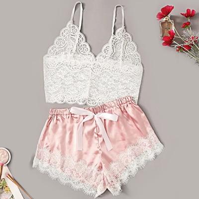 Lacy white bralette paired with soft pink satin shorts featuring lace trim and a bow tie, perfect for a stylish and comfortable nightwear look.