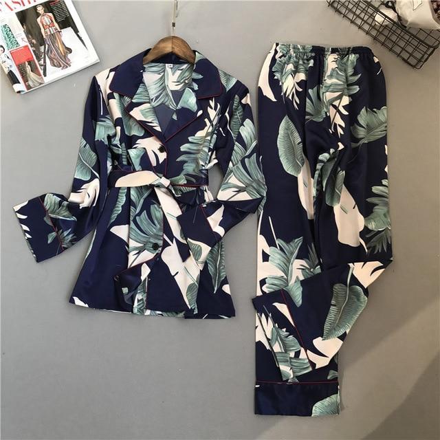 Floral navy blue women's loungewear set featuring a belted long-sleeve jacket and matching pants with tropical leaf prints.