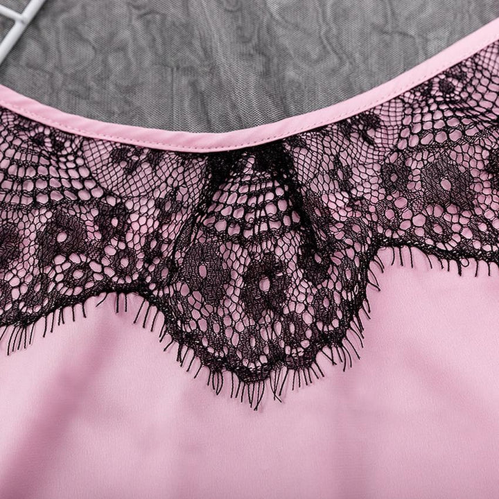 Close-up of pink lingerie fabric featuring an intricate black lace trim, showcasing elegance and femininity.