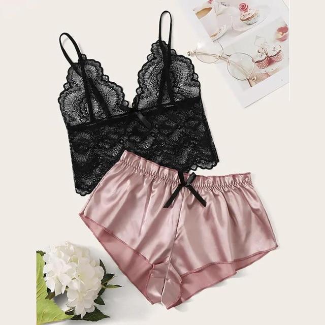 Black lace bralette and pink satin shorts lingerie set displayed with floral accents.