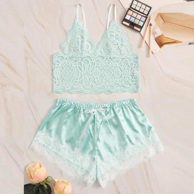 Mint green lace bralette and satin shorts set with delicate floral trim on a marble background.