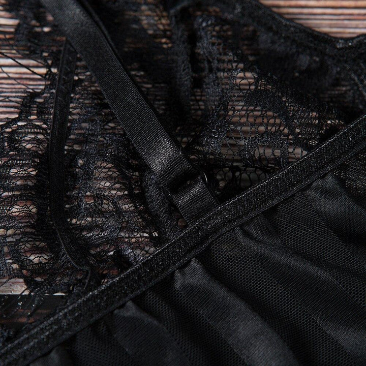 Close-up of intricate black lace detail on a lingerie piece, featuring delicate straps and soft satin accents.