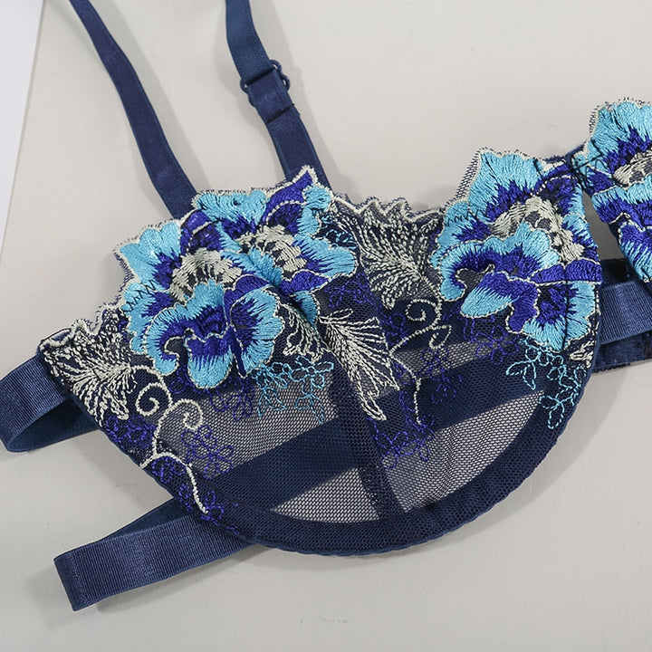 Navy blue embroidered bra with floral designs in shades of blue and silver, featuring a sheer mesh construction and adjustable straps.